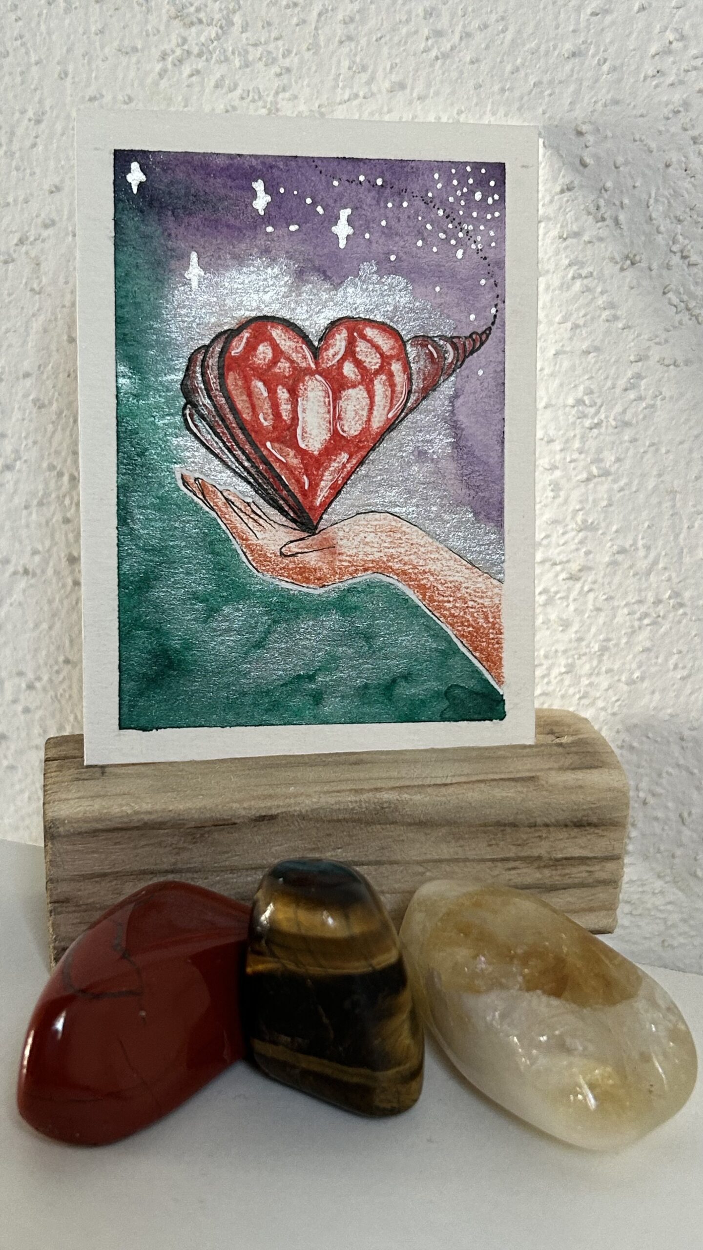 Original miniature painting “The Healer” by Nia Dannai, hand holding expanding heart symbol, watercolor and mixed media, Divine Feminine Energy series